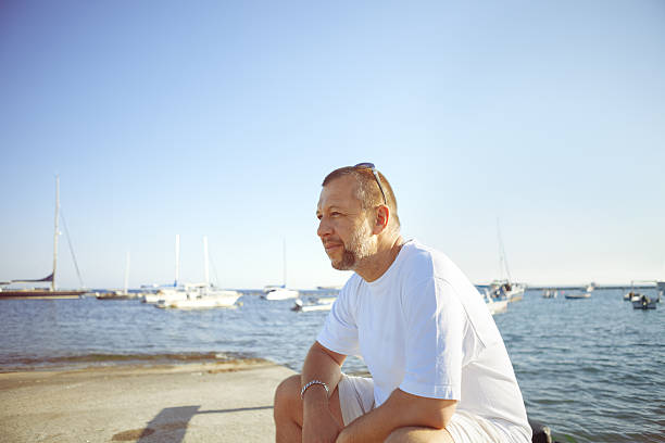 istock Mature Man Sitting on the Beach 468987697