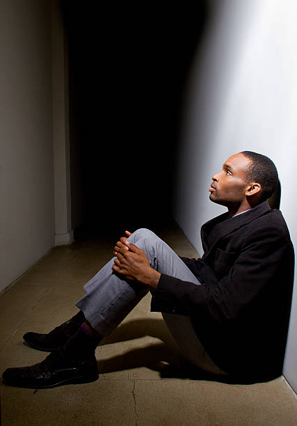 istock Depressed Man Sitting in a Dark Hallway Alone Loosing Faith 468992708