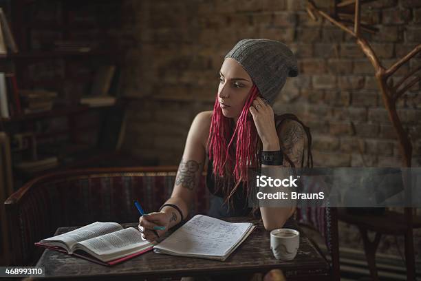 Pensive Hipster Student Studying And Looking Away Stock Photo - Download Image Now - 2015, Adult, Adults Only