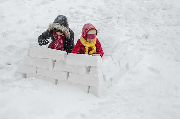 two sisters building a snow home