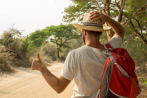 istock Backpacker man hitchhiking on desert road 468996008