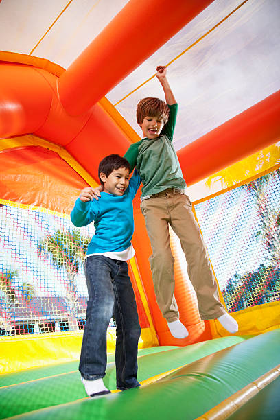 jungen in bounce house - house bouncing multi colored outdoors stock-fotos und bilder