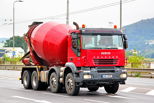 Usti nad Labem, Czech Republic - July 21, 2014: Red concrete mixer truck Iveco Trakker drives at the city street.