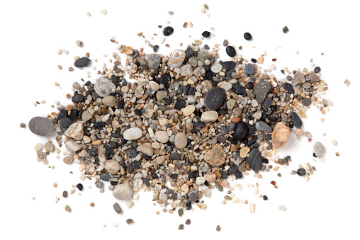 Stack of sand and small pebbles on white background