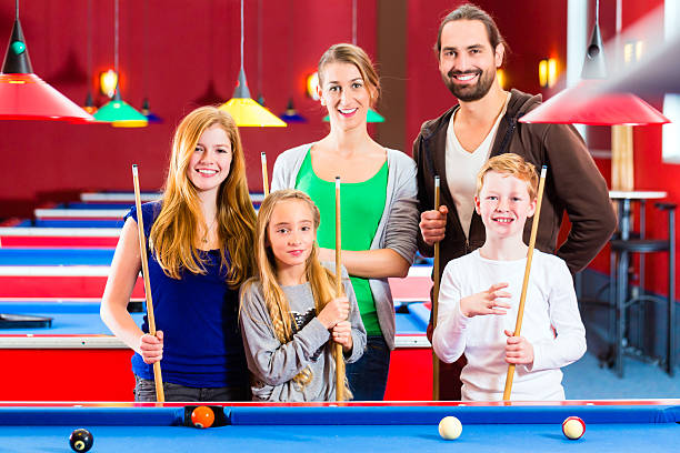 istock Family playing pool billiard game 469003565