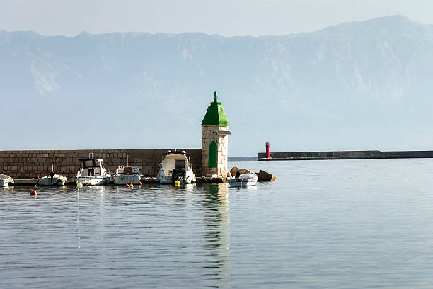 Ancient green lighthouse Lighthouse on breakwater in harbor Jelsa in Croatia jelsa stock pictures, royalty-free photos & images