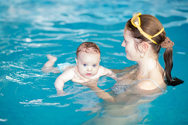 istock Little baby with blue eyes learning to swim 469004533