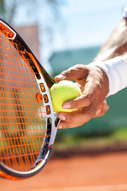 istock hand with tennis ball and racket 469012861
