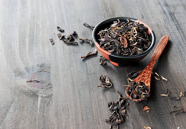 istock bowl with black tea and spoon on a wooden 469023920