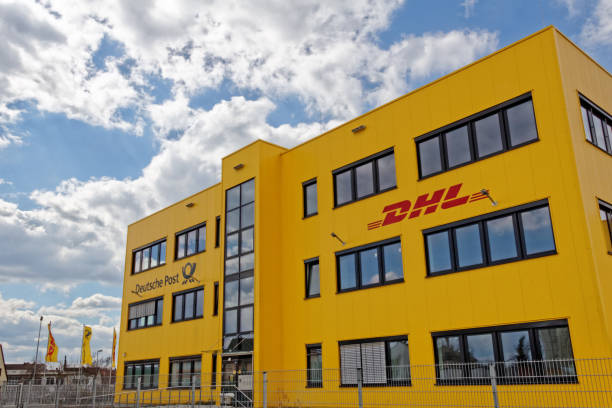 DHL and Deutsche Post building in Germany Fuerth, Germany - April 6, 2015: A yellow business building of DHL and Deutsche Post in Germany at daylight. The building belongs to a distributor center of the DHL and Deutsche Post Group. DHL is part of Deutsche Post providing international mail services. fuerth stock pictures, royalty-free photos & images