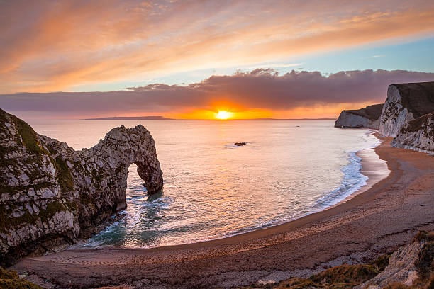 Durdle Door Dorset England Sunset at Durdle Door natural limestone arch on the Jurassic Coast near Lulworth in Dorset England UK Europe durdle door stock pictures, royalty-free photos & images