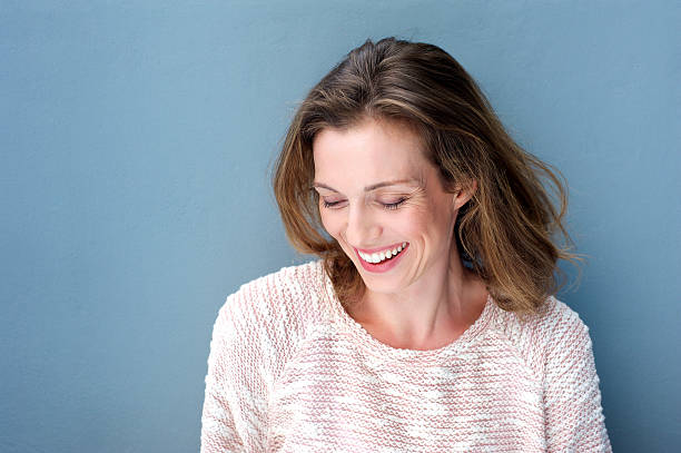 hermosa mujer de mediana edad riendo con jersey - mid adult women fotografías e imágenes de stock