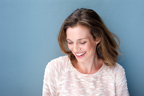Close up portrait of a beautiful mid adult woman laughing with sweater