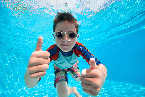 niño nadando bajo el agua - child swimming pool swimming little boys fotografías e imágenes de stock