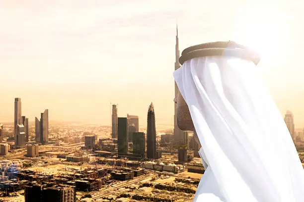 Photo of Sheikh looking to Dubai downtown skyscrapers and office buildings