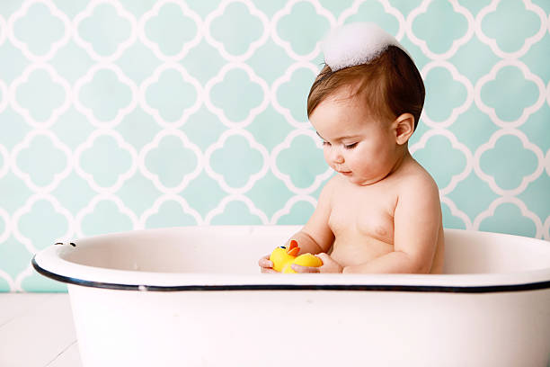 Baby with Rubber Ducky in Antique Bathtub stock photo