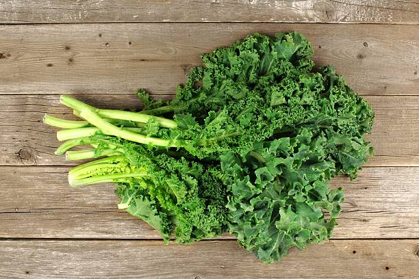 istock Bunch of kale over a wooden background 469044738