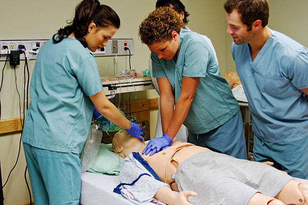 Medical staff practicing CPR Medical staff practice CPR on mannequin cpr stock pictures, royalty-free photos & images