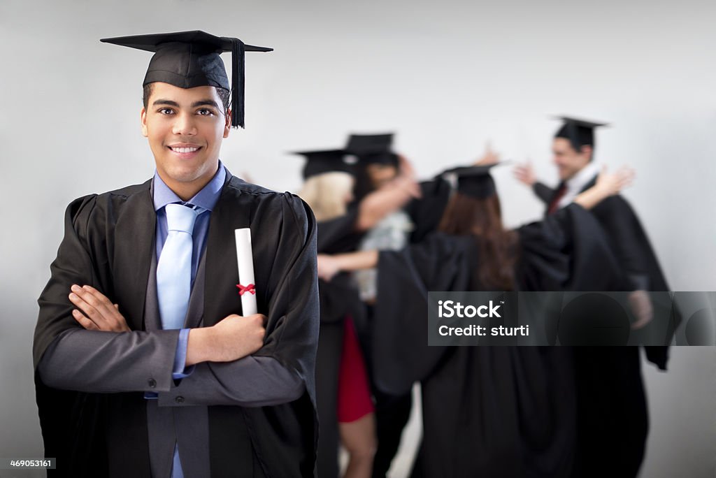 proud graduate female graduate looks determined with blurred graduates in the background 20-29 Years Stock Photo