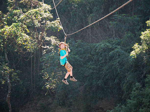 dzielna mały chłopiec w hełm i okablowania na suwak wyściółka - zip lining zdjęcia i obrazy z banku zdjęć