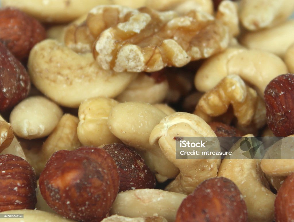 Image of healthy mixed nuts, almonds, cashews, hazelnuts, walnuts, fibre Photo showing some mixed nuts pictured close-up, waiting to be eaten as a healthy snack that can be enjoyed in between meals, with the protein in the nuts being perfect to wake you up on a sleepy afternoon.  The mixture of nuts includes almonds, cashews, hazelnuts and walnuts. 2015 Stock Photo