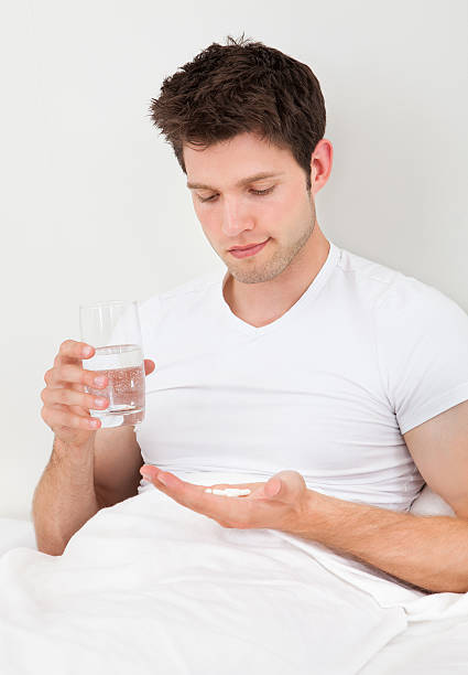 istock Man Holding Medicine And Glass 469056717