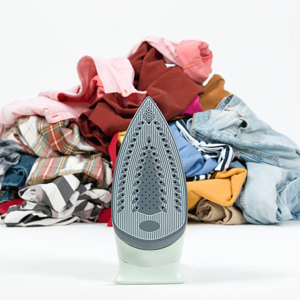 istock Iron with a pile of clothes on white background 469056720