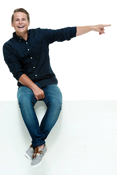 istock Smiling casual man on box and pointing 469057604