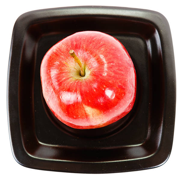 apple on a black plate stock photo