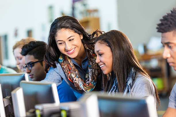 glückliche hispanic lehrer helfen high-school-schüler, die mit computer. - school gymnasium fotos stock-fotos und bilder