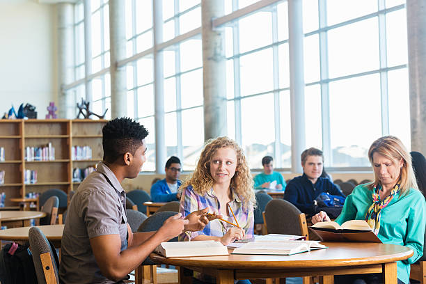 istock High school girl studying with tutor while mom reads nearby 469067276