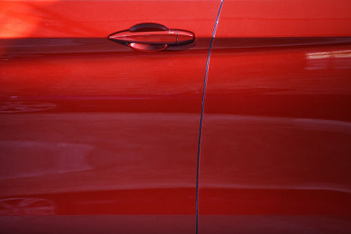 Color detail of a red car door handle.
