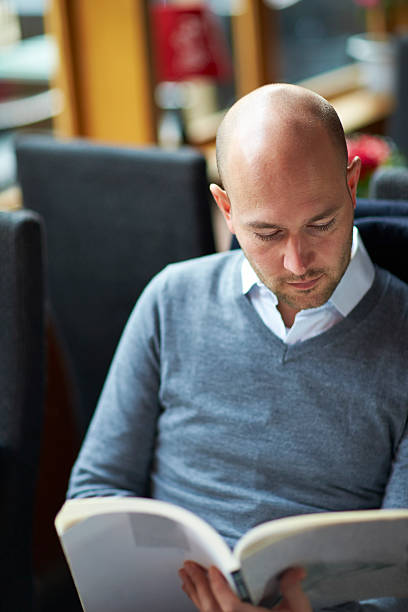 istock young man reading book in cafe 469069022