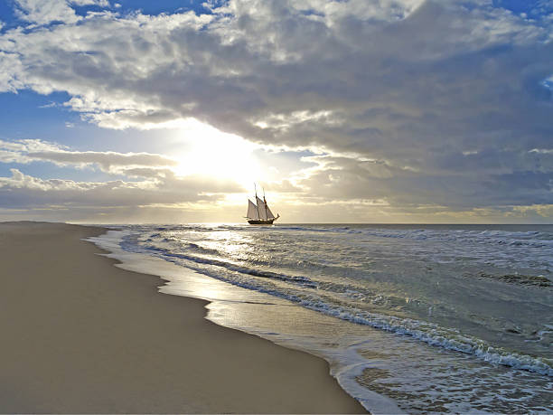 barco à vela, na praia, mar e sol - moody sky water sport passenger craft scenics imagens e fotografias de stock