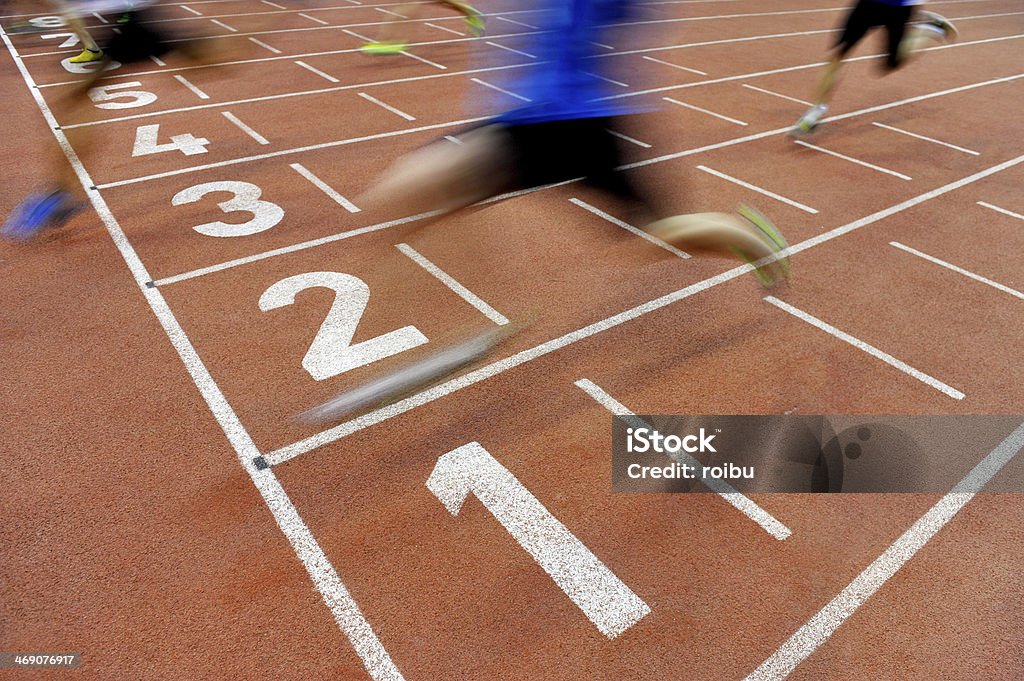 Athletes cross the finish line Blurred athletes by a slow camera shutter speed are crossing the finish line after sprint track Finish Line Stock Photo