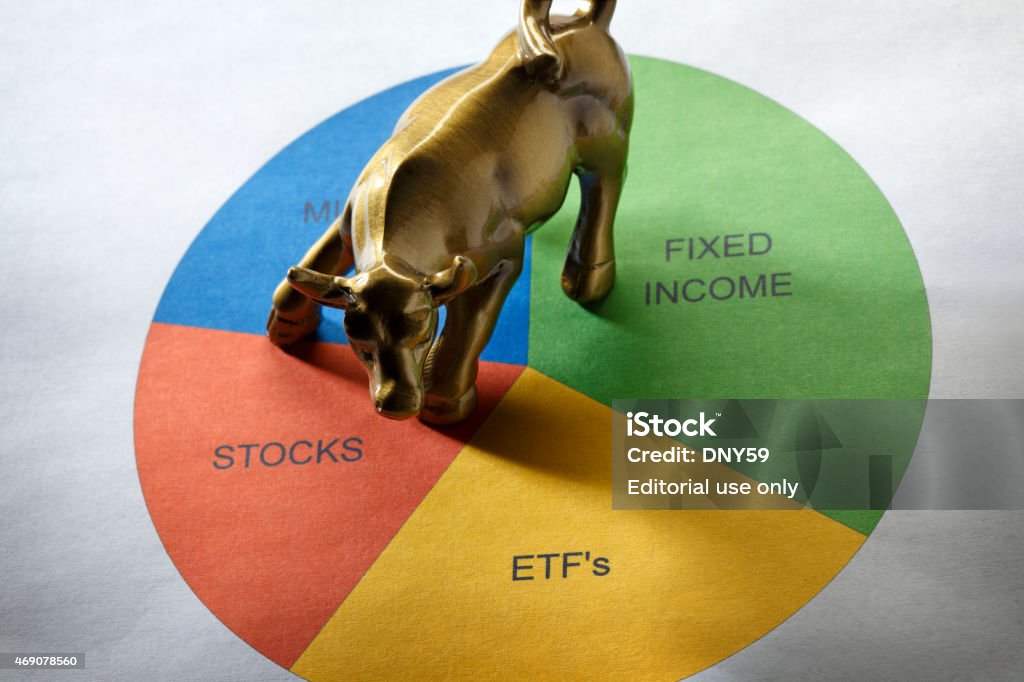 Asset Allocation San Diego, California, USA - January 7, 2015: A miniature replica of the famous Charging Bull, by artist Arturo Dimodica, sitting on a pie chart indicating asset allocation of investments. Wealth Stock Photo