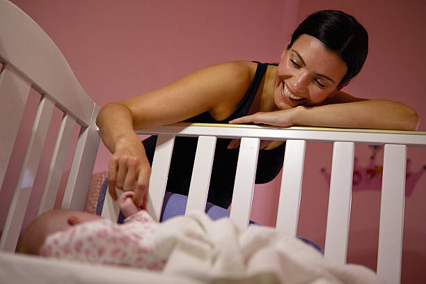 istock Mother Playing Game With Newborn Baby In Cot 469082944