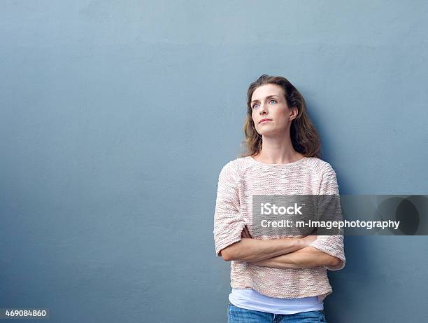Woman With Arms Crossed Looking Away With Thoughtful Expression Stock Photo - Download Image Now