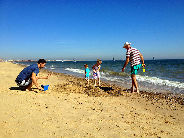 famille sur la plage - sandcastle beach norfolk sand photos et images de collection