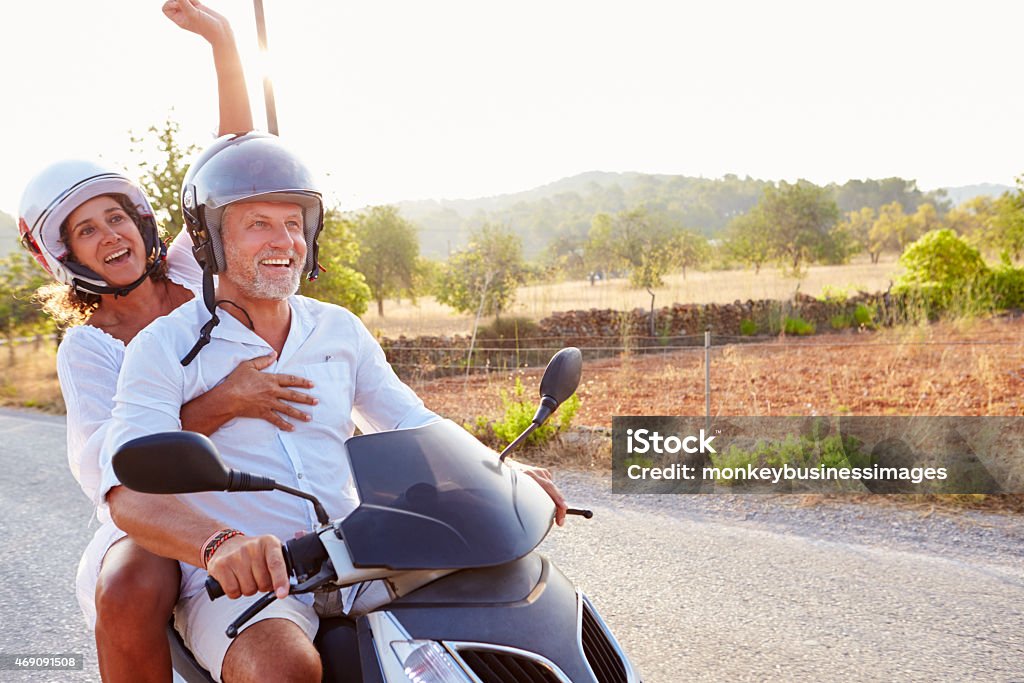 Mature Couple Riding Motor Scooter Along Country Road Mature Couple Stock Photo