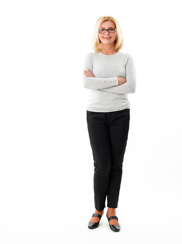 Full length portrait of smiling mature businesswoman standing against white background.