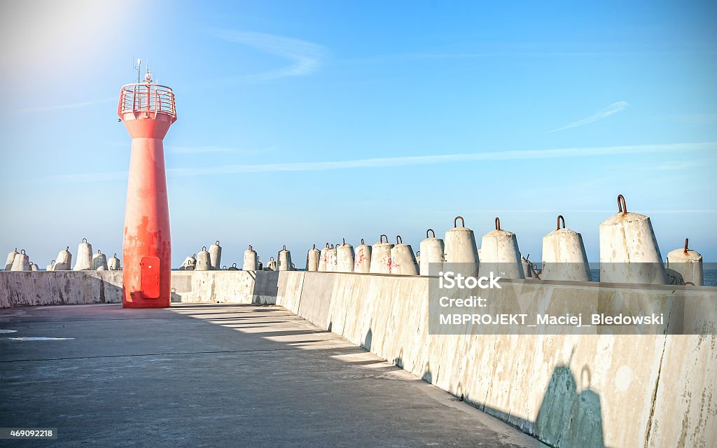 Photo of a lighthouse and concrete block breakwater. 2015 Stock Photo