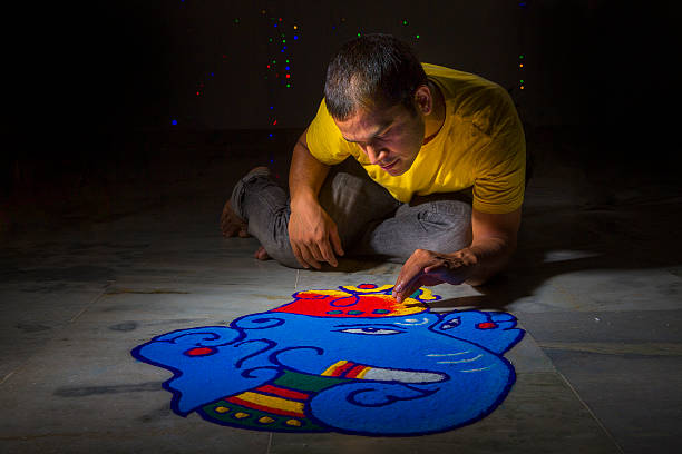 młody mężczyzna dokonywanie rangoli przy okazji diwali - powder paint tribal art colors art zdjęcia i obrazy z banku zdjęć