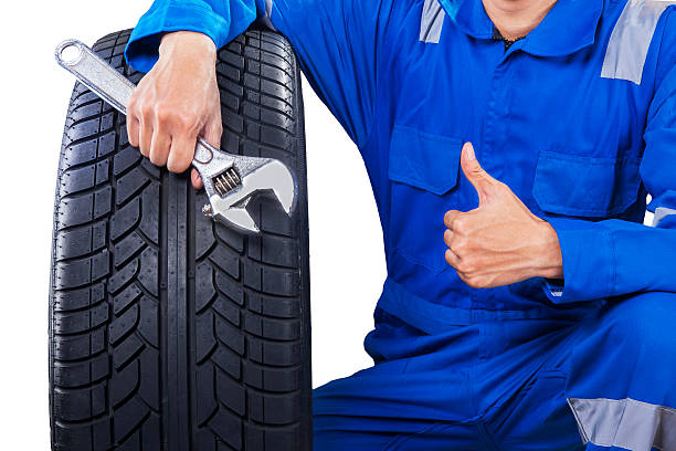 istock Mechanic with a tire showing thumb up 469097872