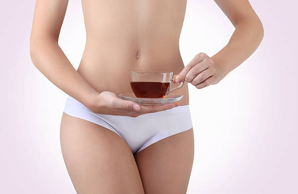 istock hands with a cup of tea near the belly 469098505