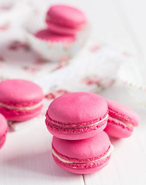 istock Pink raspberry macaroons on white wooden background 469100006