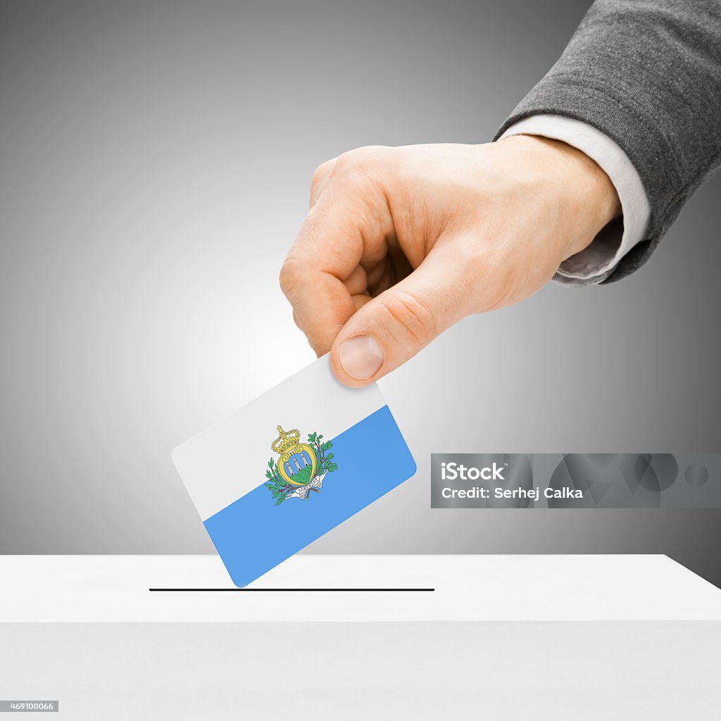Male inserting flag into ballot box - San Marin Voting concept - Male inserting flag into ballot box - San Marino 2015 Stock Photo