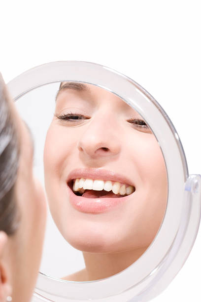 istock Young woman looking into mirror, smiling, portrait 469100122
