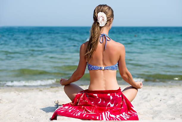donna meditare al mare - equanimity foto e immagini stock
