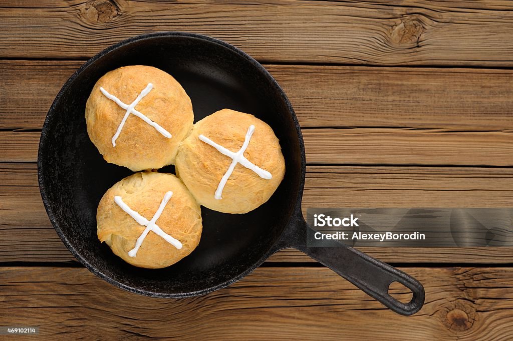 Hot cross buns in cast iron skillet on wooden background Hot cross buns in cast iron skillet on wooden background with space 2015 Stock Photo